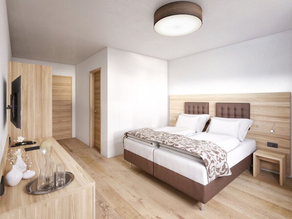 A modern hotel room with a wooden floor, a bed with a headboard, a bedside table, a TV mounted on the wall, and a small table with a vase and glasses.