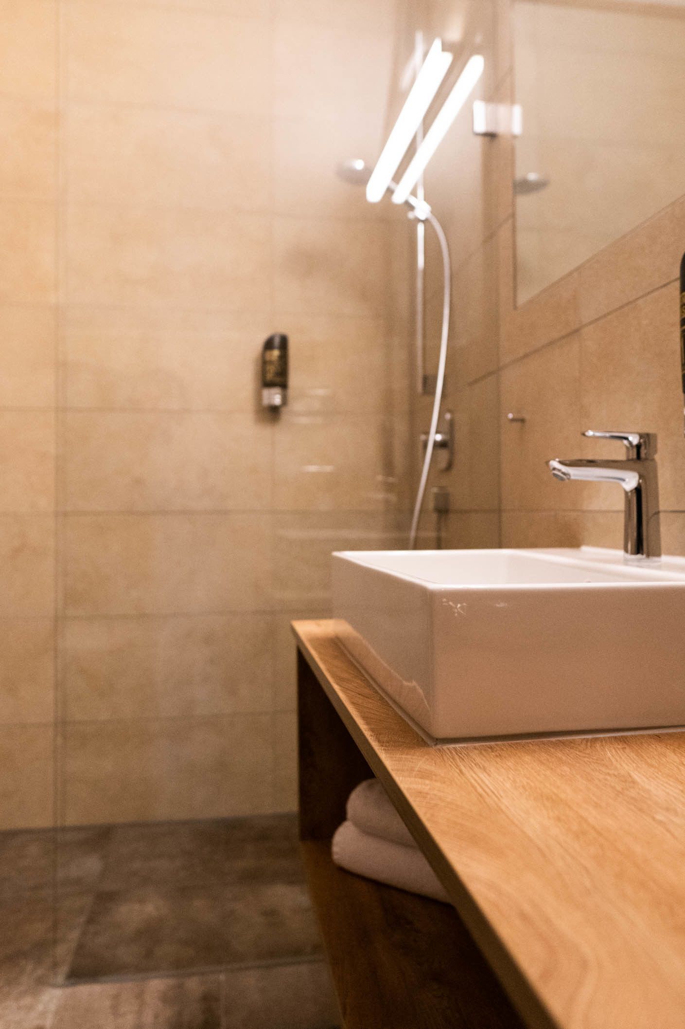 Une salle de bain moderne avec un meuble-lavabo en bois, un lavabo blanc et un miroir.