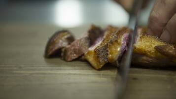 A close-up of a steak being sliced on a wooden cutting board.
