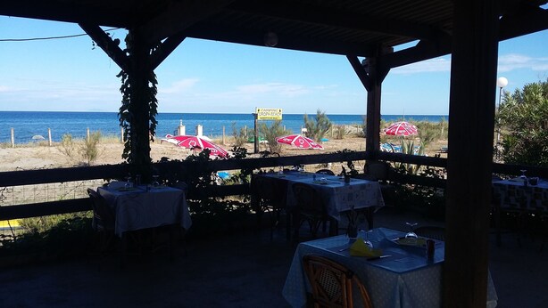 A beachside restaurant with tables and umbrellas overlooking the sea. - Camping Europa Beach (Sorbo-Ocagnano)