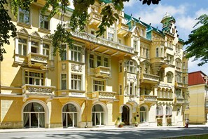 Un edificio histórico con balcones ornamentados, amplias ventanas arqueadas y un estilo arquitectónico clásico.