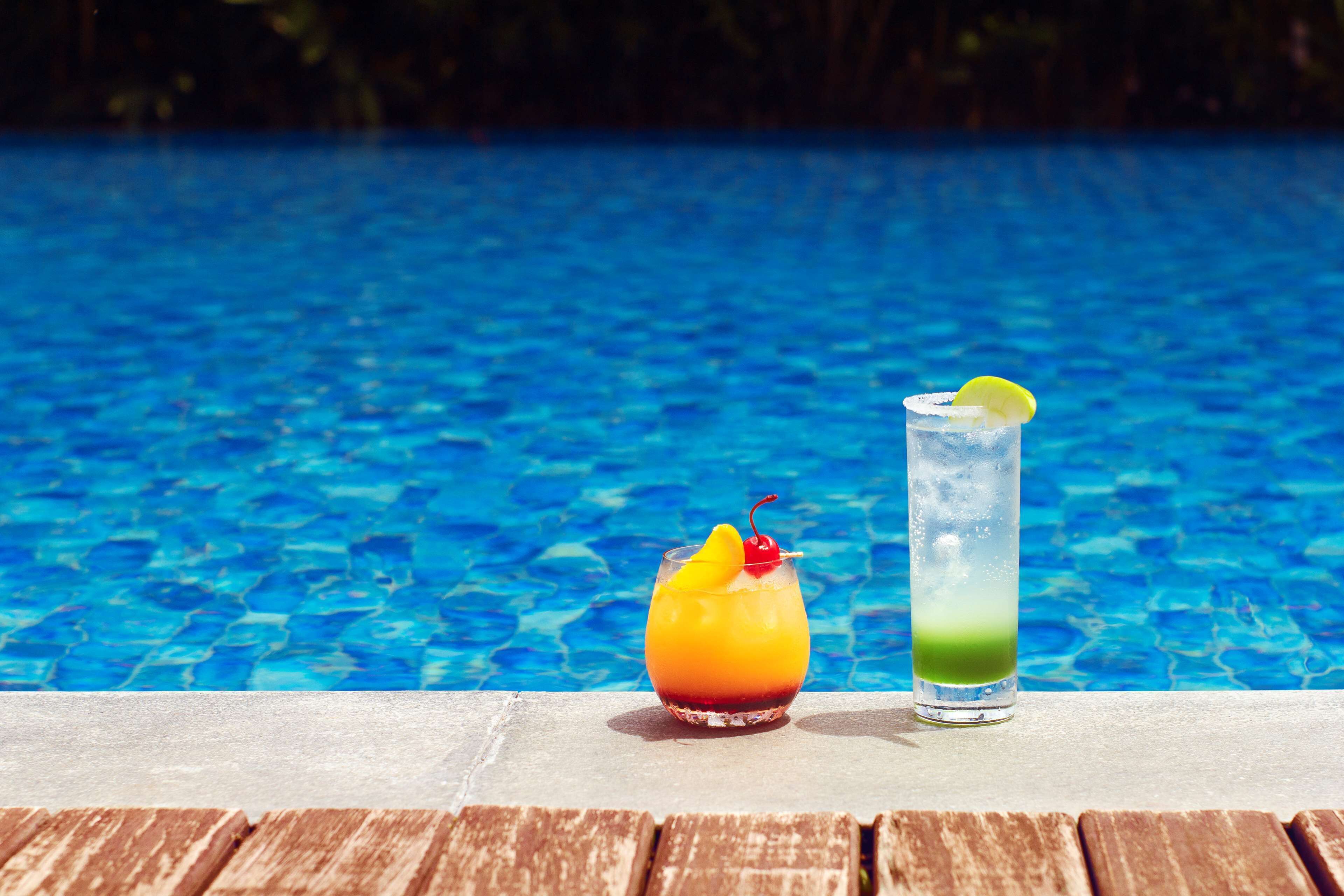 Dos bebidas junto a una piscina.