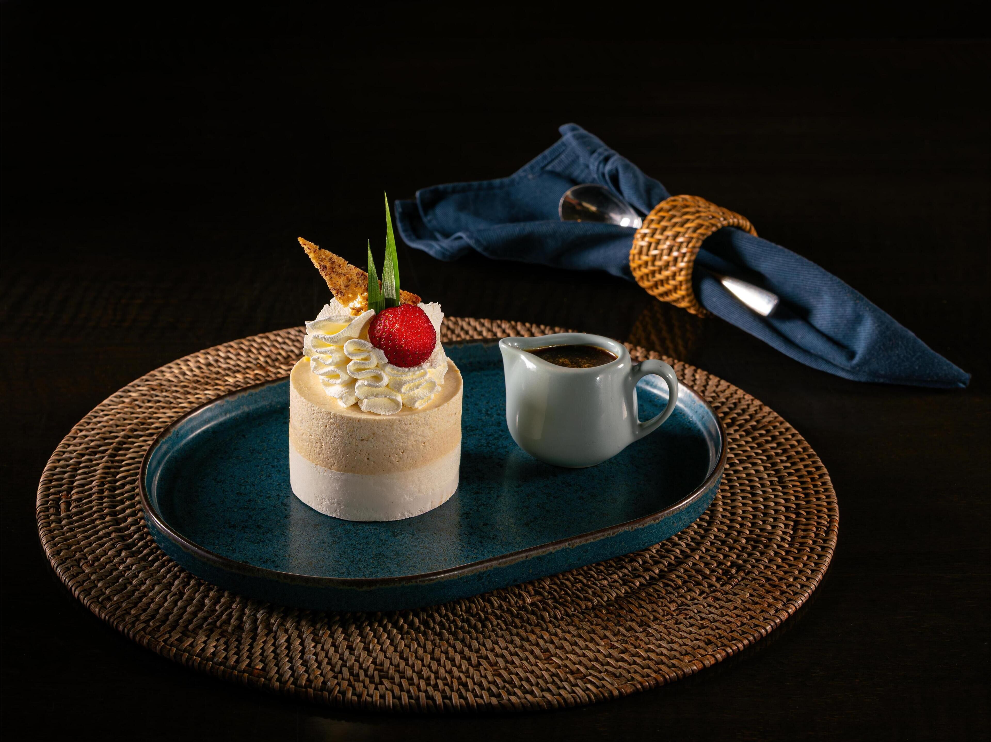 A dessert on a tray with a small cup of coffee beside it.