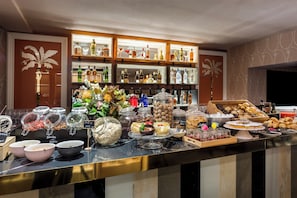 A buffet area with a variety of food options, including fruits, nuts, and pastries.