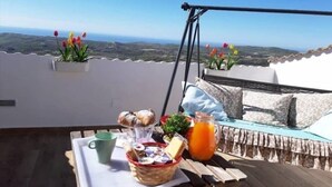 Desayuno dispuesto en una terraza con vistas al paisaje.