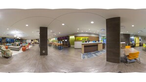 A spacious lobby with a reception desk, seating areas, and a children's play zone. - Home2 Suites BY Hilton Hagerstown (Hagerstown)