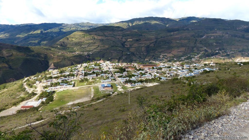 A town nestled in a valley with a mix of residential and commercial buildings, surrounded by hills.