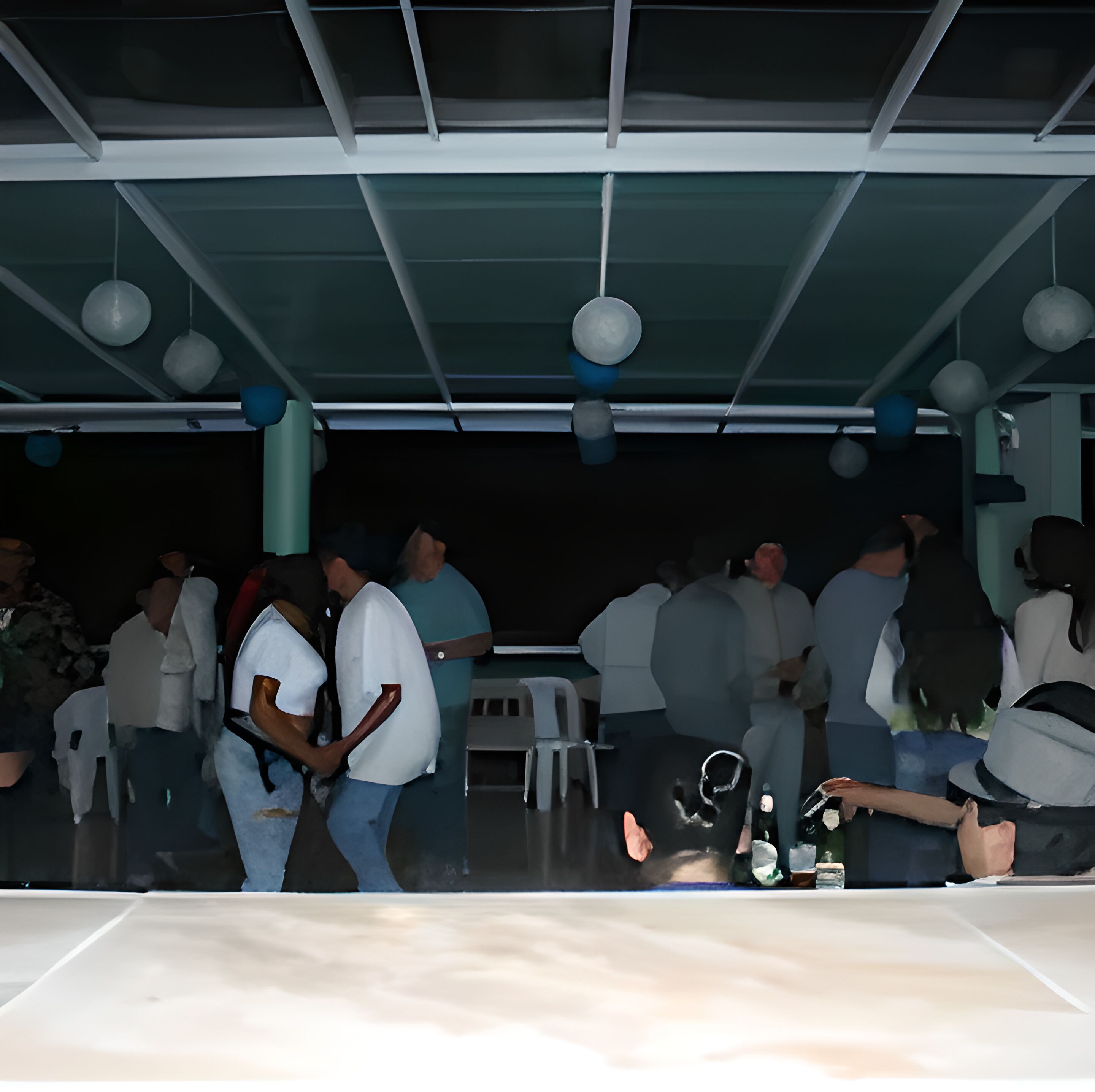 A covered outdoor seating area with tables and chairs, a ceiling with hanging lights, and a dark background.