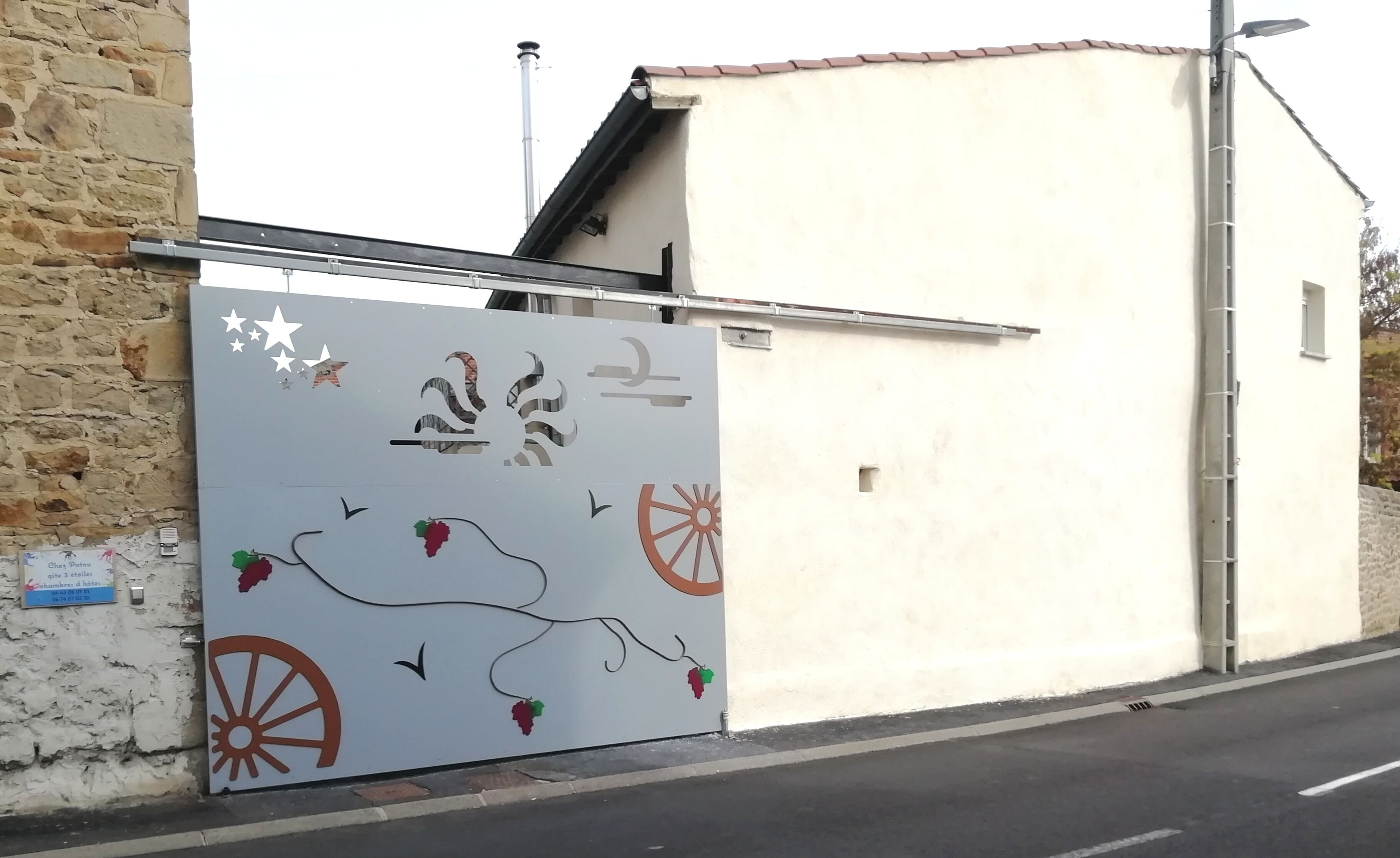 Un edificio de fachada blanca y una reja metálica con adornos decorativos.