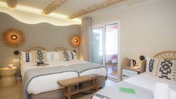 A hotel room with two beds, a wooden bench, a small table with a kettle, and a view of the outside.