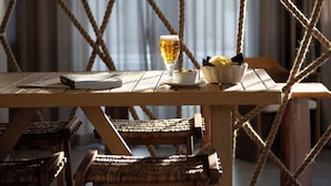 Ein Holztisch mit einem Bierglas, einer Schüssel Chips und einem Buch.