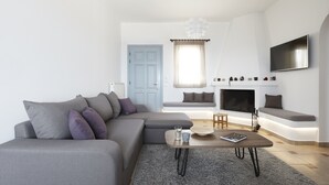 Un soggiorno moderno con un divano modulare grigio, un tavolino da caffè e un caminetto.