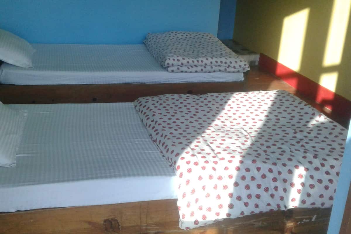 Two bunk beds with striped bedding and a polka-dotted blanket.