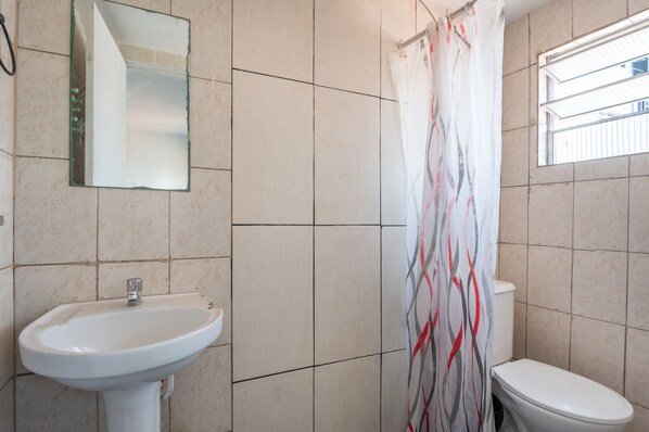 A bathroom with a sink, toilet, and a shower curtain. - OYO Nações Unidas, São Paulo (São Paulo)