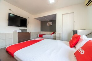 A hotel room with a large bed, a TV mounted on the wall, a small desk, and a door leading to another room. - OYO Nações Unidas, São Paulo (São Paulo)