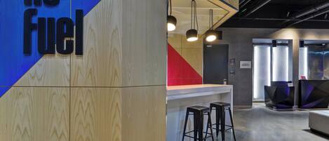 A modern office space with a reception area, bar stools, and a counter.