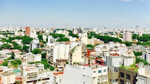 Un quartier urbain densément peuplé, caractérisé par une grande variété de hauteurs de bâtiments et de styles architecturaux, dont certains sont dotés de toits végétalisés.