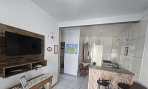 Une cuisine moderne avec un revêtement mural en carreaux, une cuisinière encastrée et un petit coin repas comprenant une table et des chaises.
