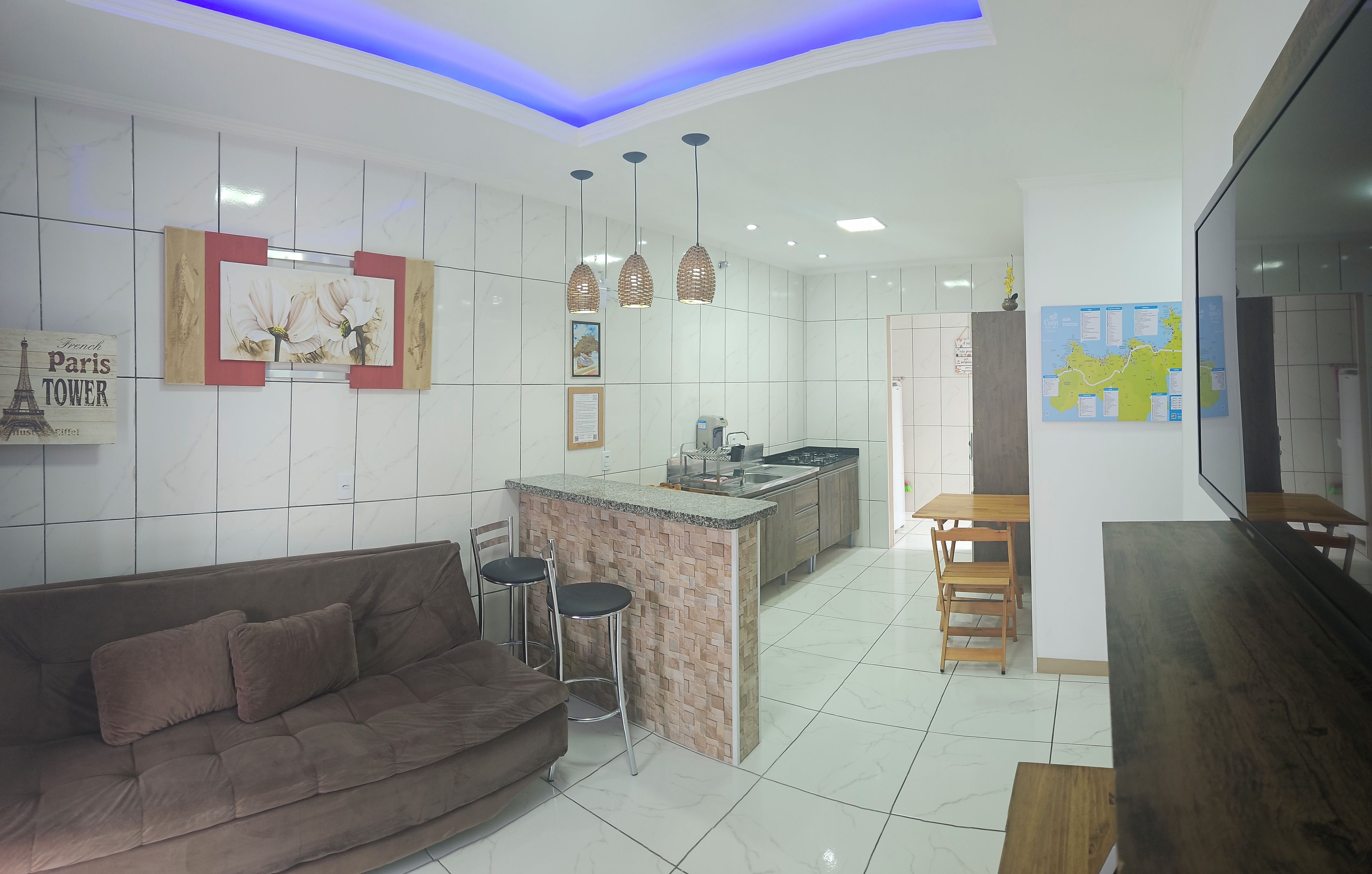 A modern kitchen with a central island, bar stools, and a dining table.