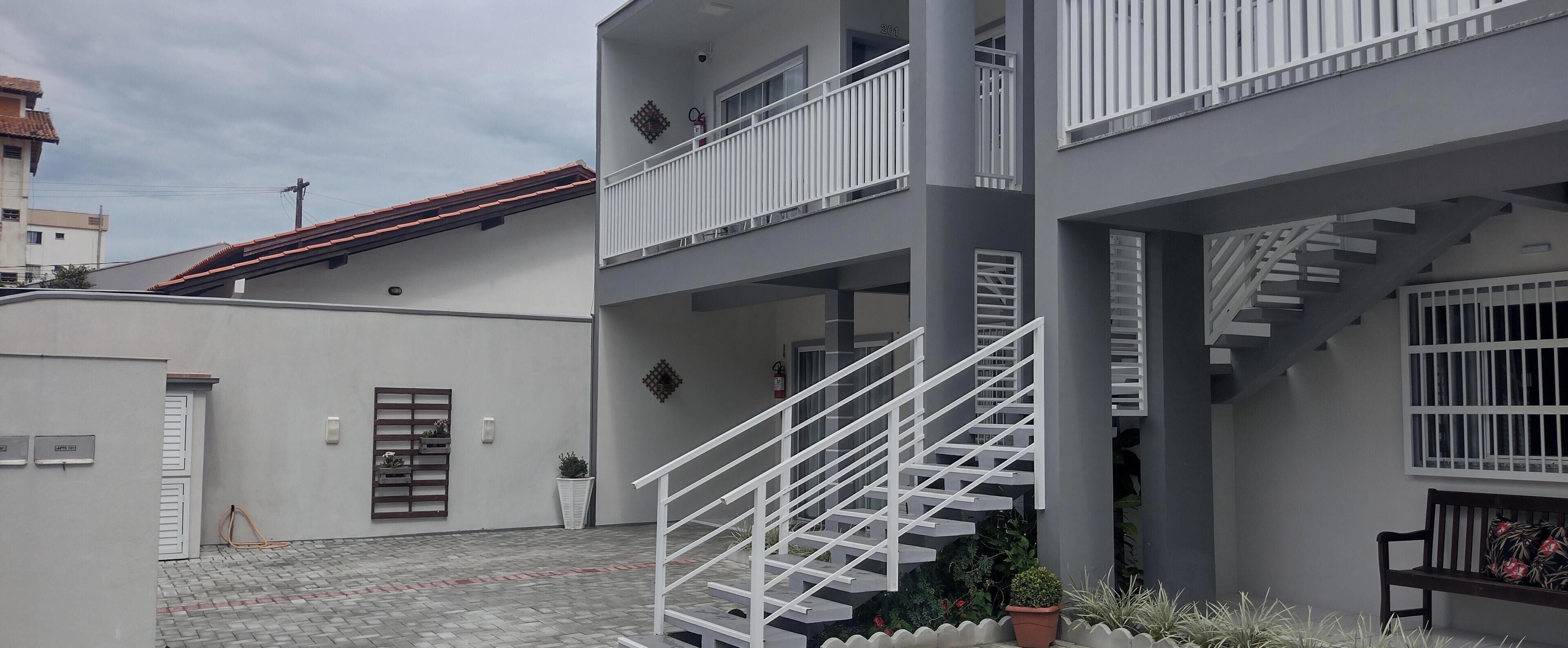 A multi-story building with a central staircase, exterior walls, and a small garden area.