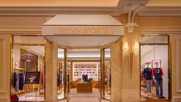 A WYNN SPORTS store with a modern interior, featuring mannequins displaying sportswear and a variety of hats on shelves.