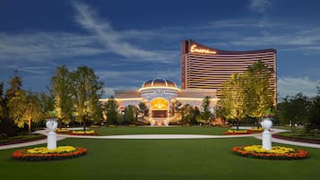 A hotel with a prominent marquee sign, a central dome structure, and well-manicured gardens with circular flower beds.