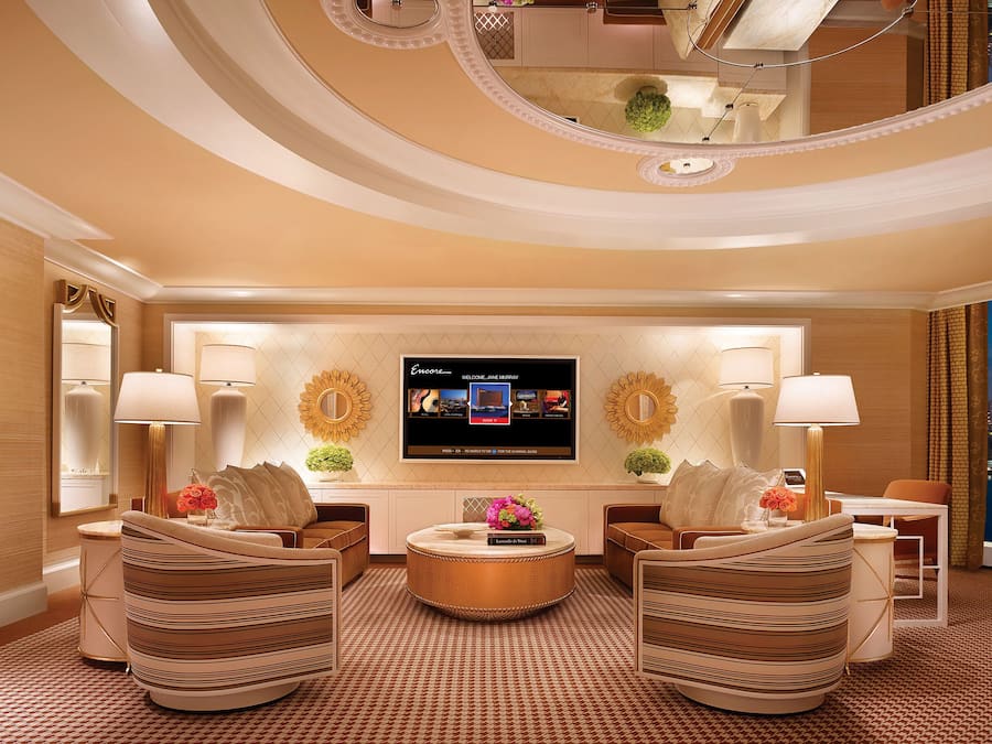 Una habitación de hotel lujosa con una gran pantalla de televisión, asientos cómodos y vistas a la ciudad.