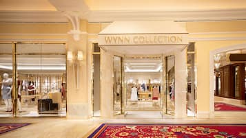 L'ingresso dell'hotel Wynn Collection, caratterizzato da una maestosa facciata in marmo, con manichini che espongono abiti e un tappeto rosso che conduce all'interno.