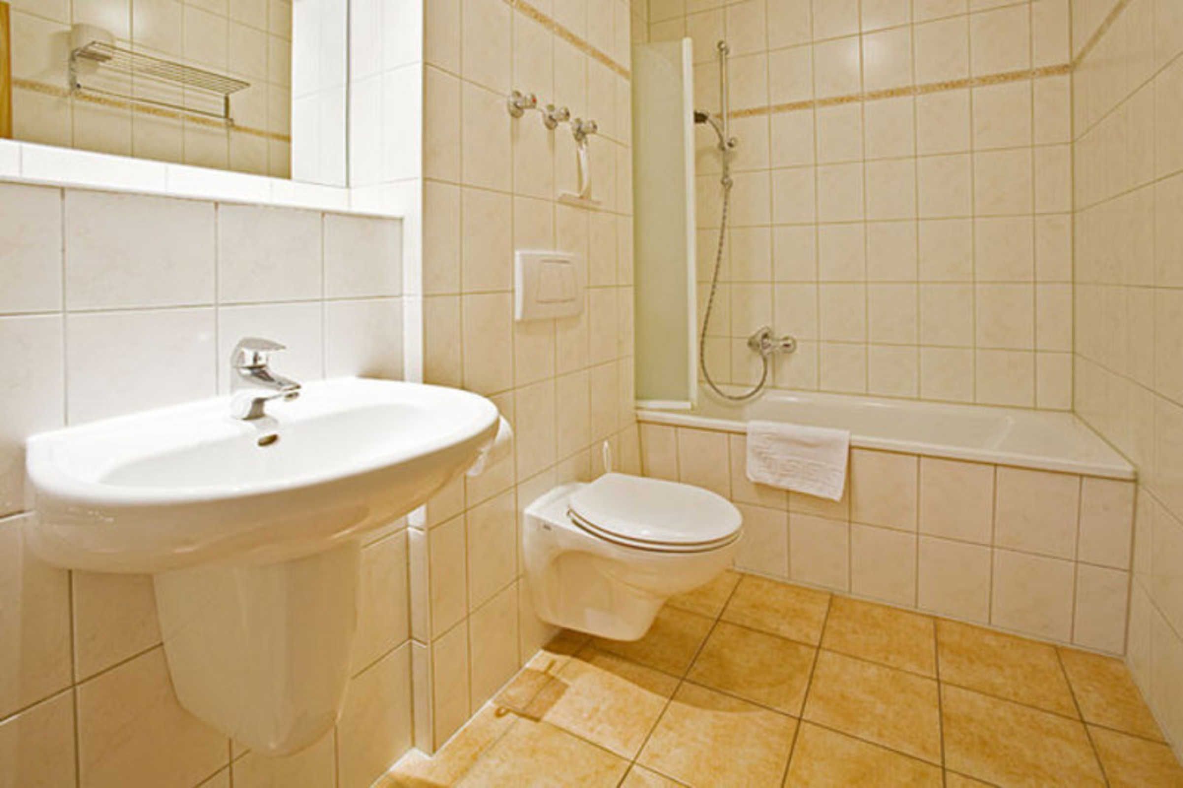 A bathroom with a sink, toilet, and bathtub.