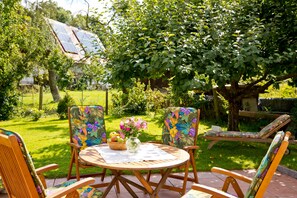 A patio with a round table, two chairs, and a lounge chair. - Apartment 2 - Apartment "am-edersee" (Edertal)