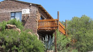 A rustic stone building with a wooden balcony.