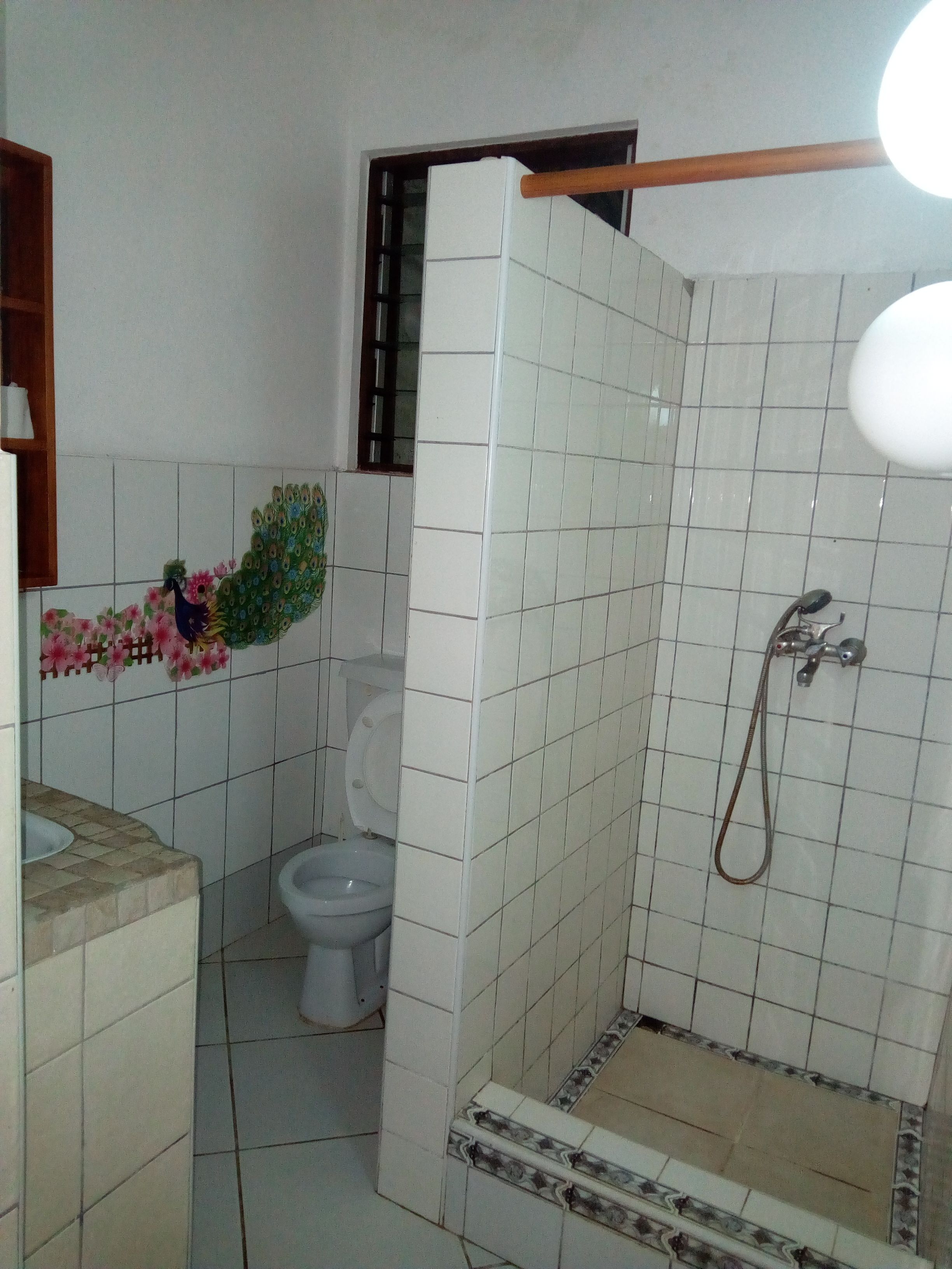 A bathroom with a shower, toilet, and sink.