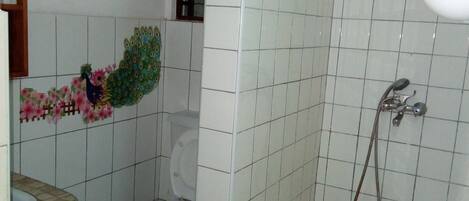 A bathroom with a shower, toilet, and sink.