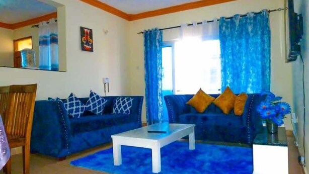 A living room with two sofas, a coffee table, and a blue rug. - Fastcare Luxury Apartments/Villas (Mtwapa)