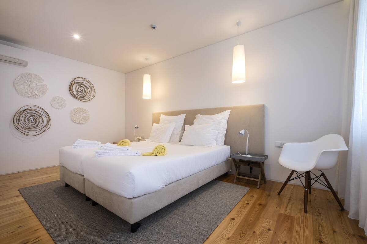 A modern bedroom with a large bed, bedside tables, and a chair.
