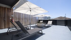 A rooftop terrace with sun loungers, umbrellas, and a fire extinguisher. - Aqua - Pópulo Eco Village (Ponta Delgada)