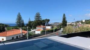 A rooftop swimming pool with a clear view of the surrounding neighborhood, including houses and a road. - Aqua - Pópulo Eco Village (Ponta Delgada)