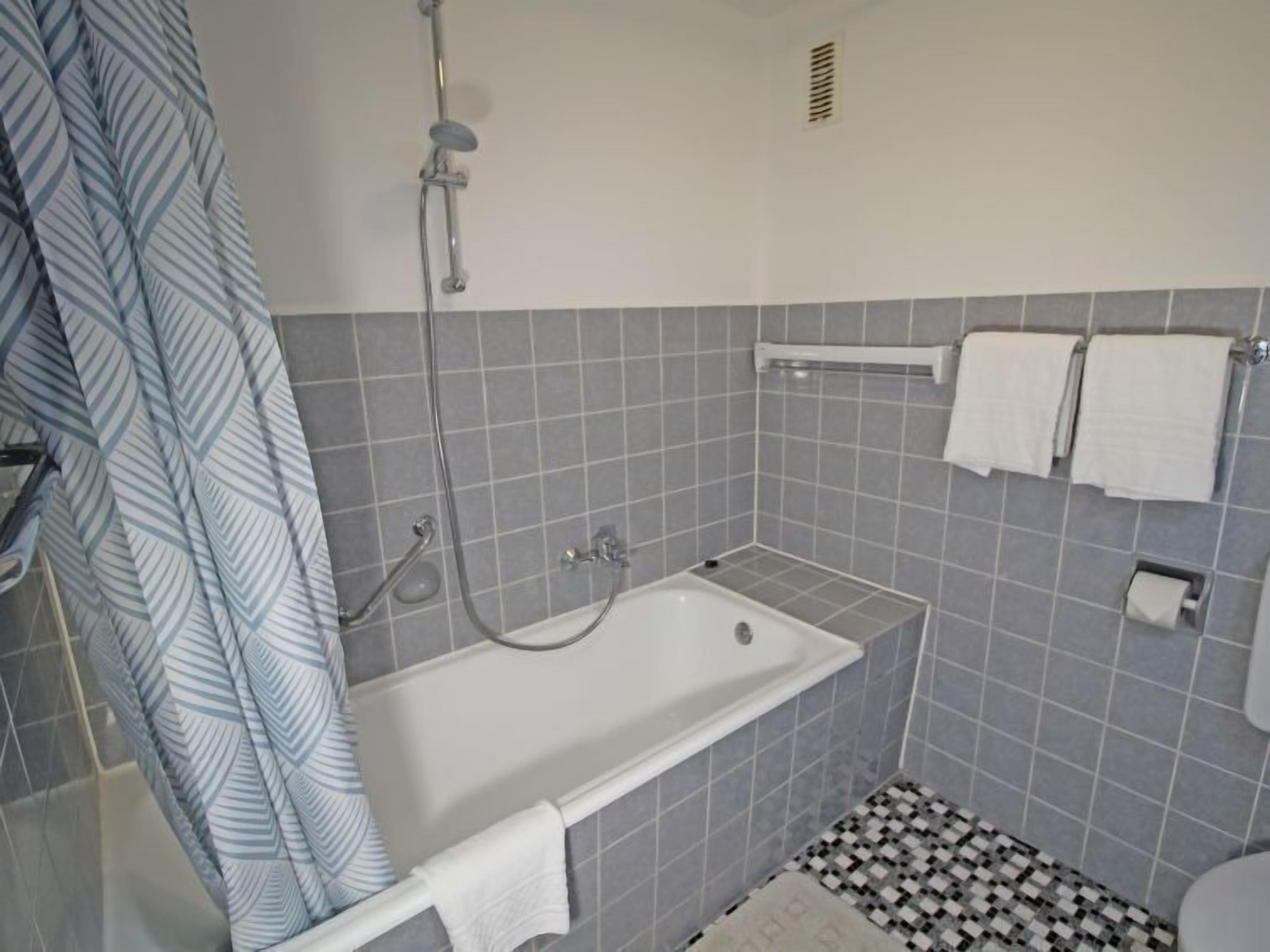 A bathroom with a bathtub, a shower, and a toilet.