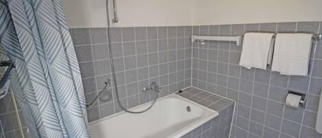 A bathroom with a bathtub, a shower, and a toilet.