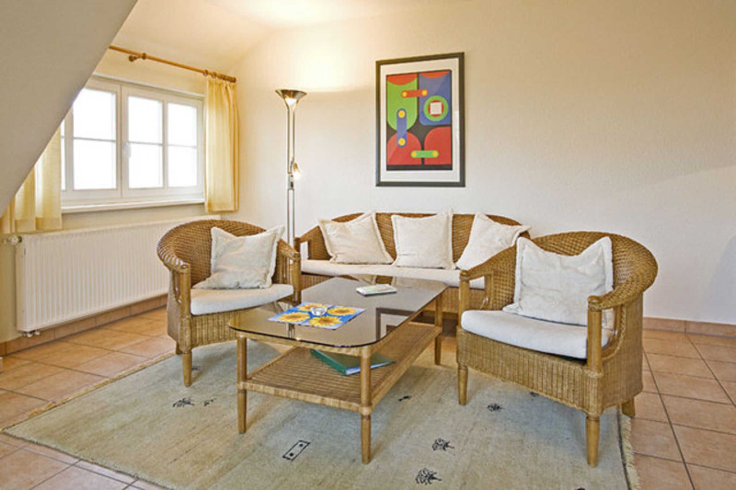 Una habitación con sofá, una mesa de centro, una lámpara de pie, un radiador y una ventana con cortinas.