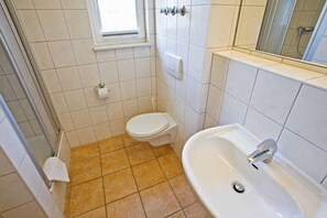 Un baño con inodoro, lavamanos y ventana.