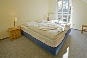 A bedroom with a bed, bedside tables, a window, and a radiator. - House Martha - Kurt - House Martha (Ahrenshoop)