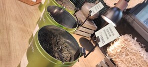 A display of green containers with labels indicating different types of tea. - ibis Styles Amiens Centre (Amiens)