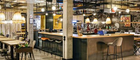A modern bar area with a central island, bar stools, and hanging pendant lights.