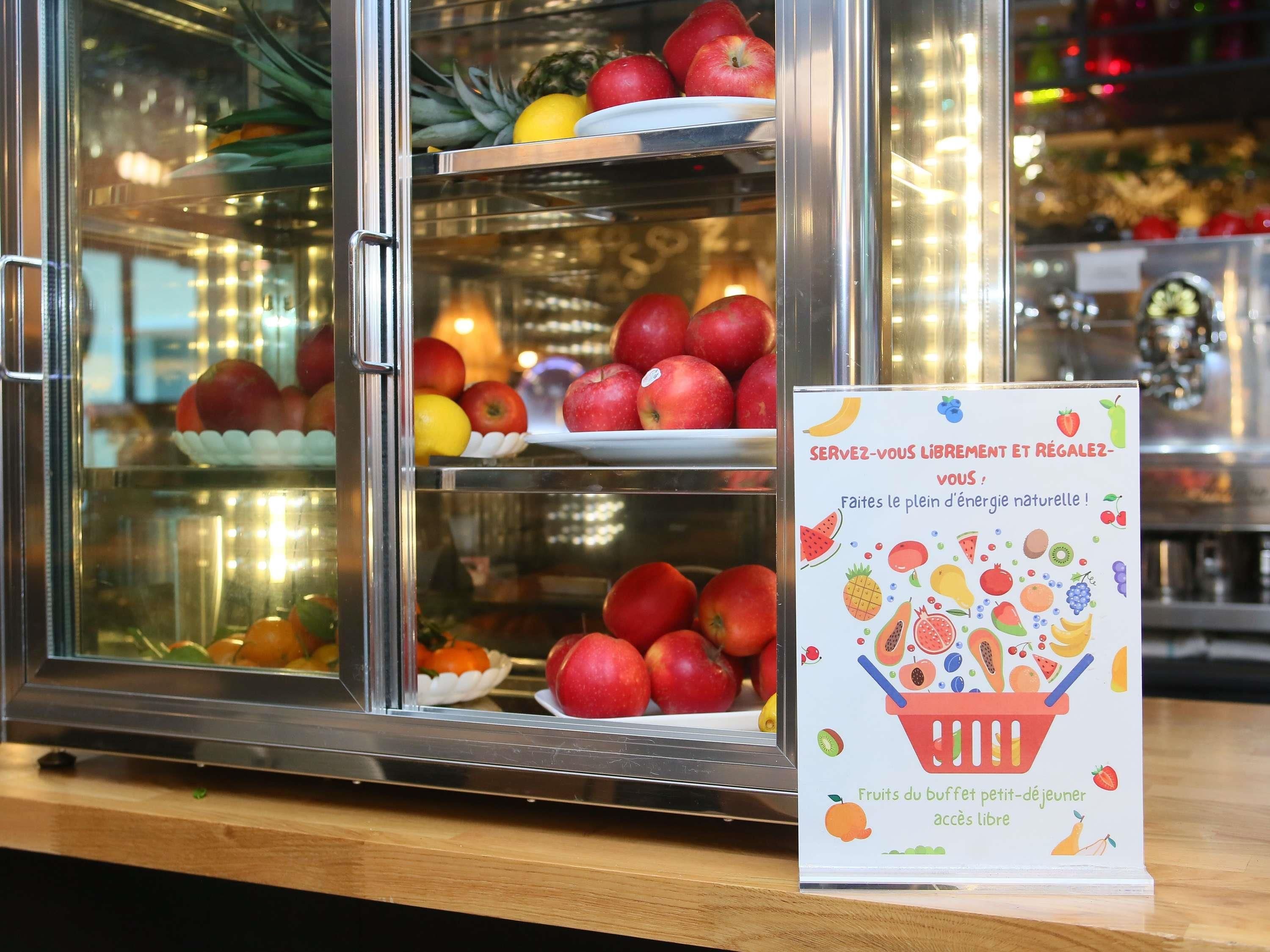 Een koelvitrine met verschillende soorten fruit en een bordje dat natuurlijke energie promoot.