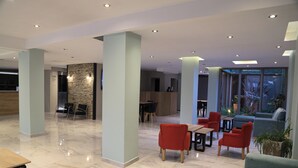 A spacious lobby with a marble floor, seating areas, and a reception desk. - Hotel Bariloche Ski (San Carlos de Bariloche)