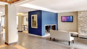 A modern interior with a blue accent wall, a fireplace, a flat-screen TV, and a seating area. - Hotel Bariloche Ski (San Carlos de Bariloche)