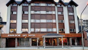 A multi-story hotel with a wooden facade and a covered entrance. - Hotel Bariloche Ski (San Carlos de Bariloche)