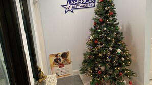 Un árbol de Navidad decorado con un cartel de Americas Best Value Inn en la pared.