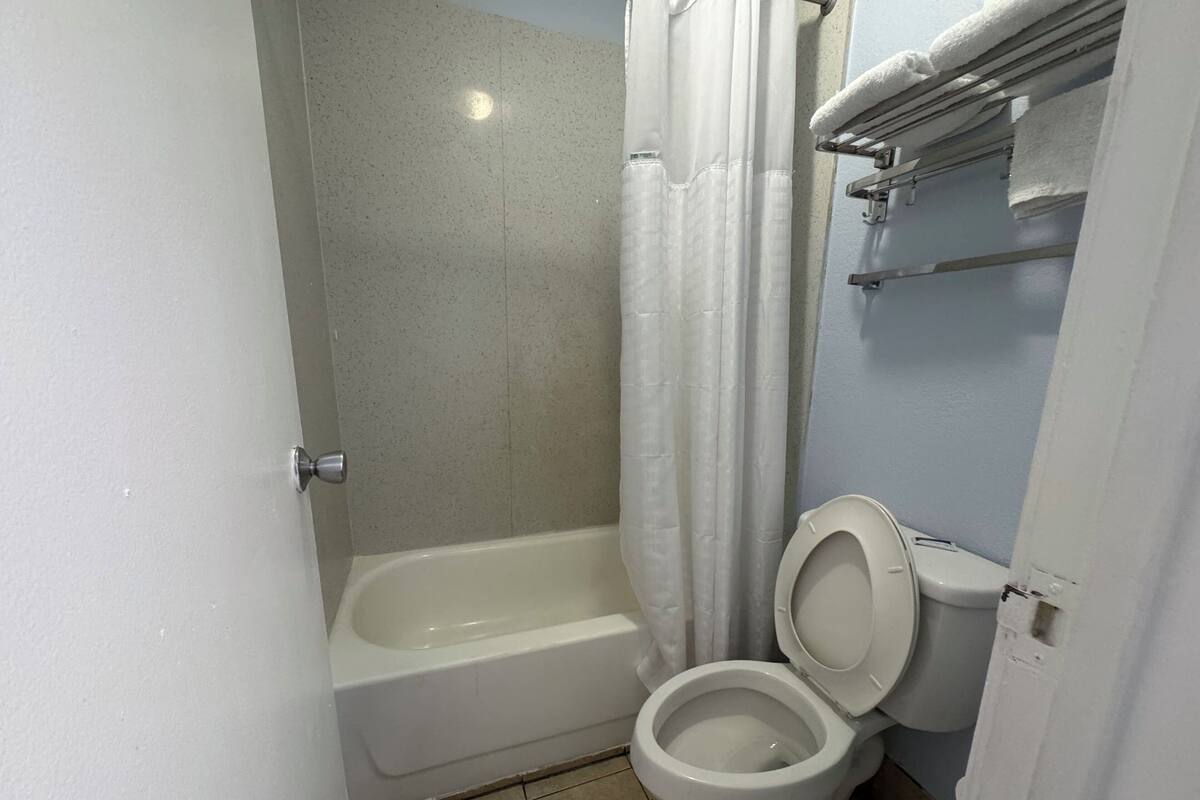 Kylpyhuone, jossa on kylpyamme, wc ja suihkuverho.